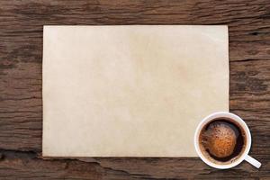 papel em branco velho e uma xícara de café em madeira foto