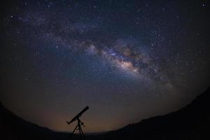 telescópios com a Via Láctea, céu noturno com estrelas, fotografia de longa exposição, com grãos. foto