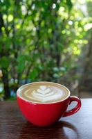 café latte art em copo vermelho foto