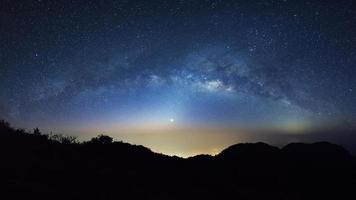 céu noturno estrelado com alta montanha em doi luang chiang dao e galáxia da via láctea com estrelas e poeira espacial no universo foto