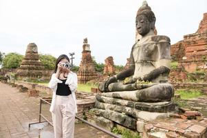 jovem mulher bonita viajando e tirando foto no parque histórico tailandês, feriados e conceito de turismo cultural.