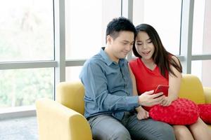 casal sorridente olhando para um telefone inteligente foto