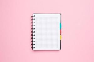 notebook em uma gaiola em um fundo rosa foto