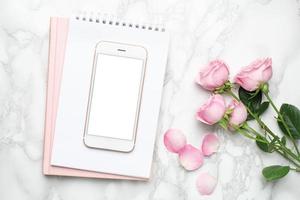 telefone móvel com flores rosas cor de rosa na composição background.minimalistic de mármore para os feriados, dia dos namorados e dia das mulheres. foto