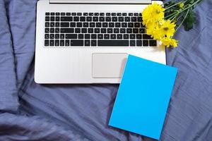 mãos, teclado de computador, vista superior da cama. fundo do local de trabalho, trabalho em casa, bloco de notas e flores foto