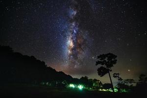 galáxia da via láctea e silhueta de árvore com nuvem no parque nacional de phu hin rong kla, phitsanulok tailândia foto