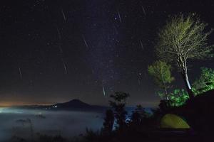 meteoro geminid no céu noturno e nevoeiro no ponto de vista khao takhian ngo em khao-kho phetchabun, tailândia foto