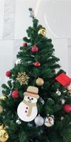 boneco de neve são pendurados na árvore de natal. foto