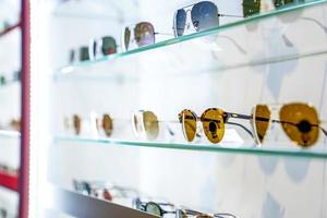lindos óculos de sol na prateleira de exposição na loja de vidro na loja de departamentos tailândia. foto