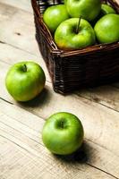 fruta. maçãs em uma cesta na mesa de madeira foto