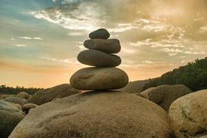 pedras equilibradas em uma praia de seixos durante o pôr do sol em bangladesh. foto