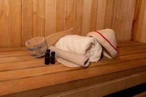 conceito de spa de balneário russo antigo tradicional. detalhes do interior sauna finlandesa sauna a vapor com acessórios de sauna tradicional conjunto toalha de bacia aroma óleo colher feltro. relaxe o conceito de banho da vila do país. foto