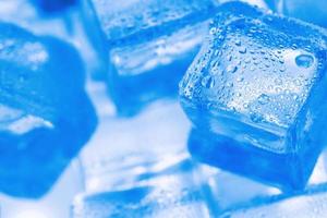 cubos de gelo com luz de fundo azul no freezer close-up em tela cheia foto