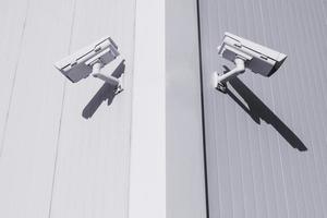 duas câmeras de CCTV em direções diferentes na esquina do prédio para controlar objetos foto