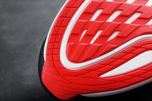 close-up da sola de um tênis esportivo para correr em vermelho foto