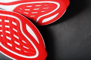 tênis de corrida com sola vermelha em um fundo preto foto