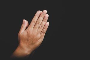 close-up mulher cristã asiática mãos pessoa orar e adorar para agradecer a Deus na igreja com fundo preto, o conceito de fé, espiritualidade e religião foto
