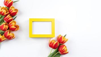 conceito de design do dia das mães, bando de flores de tulipa - lindo buquê vermelho e amarelo isolado na mesa de fundo branco, vista superior, configuração plana, espaço de cópia foto