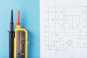 indicador de tensão de dois pólos com desenhos elétricos em um fundo azul. foto