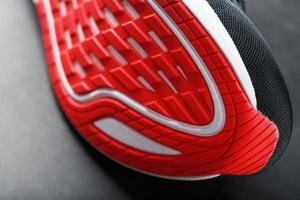 tênis com sola vermelha em um fundo preto. foto