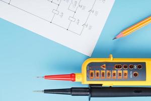 indicador de tensão amarelo com um diagrama elétrico em um fundo azul. foto