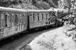 trem de brinquedo movendo-se na encosta da montanha, bela vista, uma montanha lateral, um vale lateral movendo-se na ferrovia para a colina, entre a floresta natural verde. foto