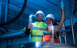 engenheiro-chefe da planta mecânica inspecionando a manutenção da máquina com os técnicos da fábrica foto