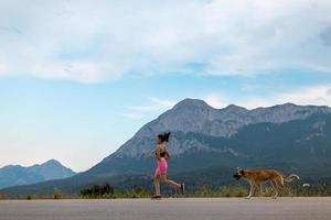 uma mulher em uma corrida noturna com um cachorro foto