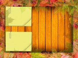 folhas de outono na velha folha de madeira e papel foto