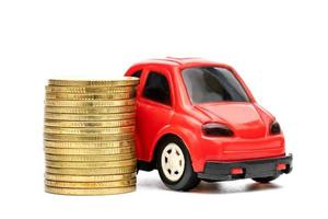 carro de brinquedo vermelho e pilhas de moedas isoladas no fundo branco foto