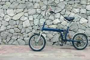 bicicleta azul com fundo de pedra, filtro de efeito vintage foto