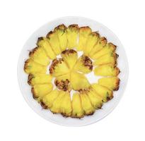 fatia de abacaxi em um prato isolado no fundo branco foto