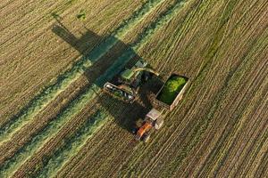 Vista aérea dos campos de colheita com colheitadeira e trator