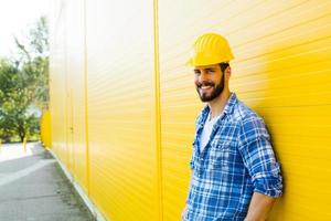 trabalhador adulto com capacete na parede amarela