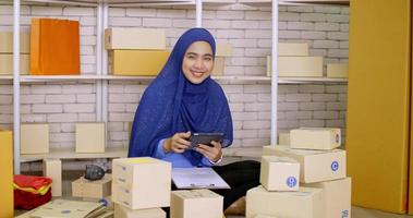 mulher de comerciante muçulmano feliz verificando o pedido on-line no escritório. foto