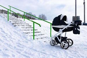 a criança dorme em um carrinho no inverno. o conceito de inverno caminha com crianças ao ar livre. foto