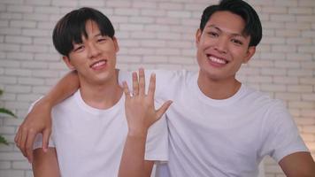 feliz casal asiático gay mostrando seu anel de casamento. foto