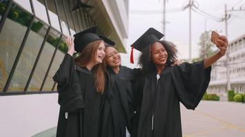 grupo de amigos se divertindo comemorando sua formatura tirando fotos juntos.