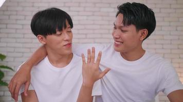 feliz casal asiático gay mostrando seu anel de casamento. foto