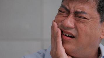 homem sênior asiático sofrendo de dor de dente. foto