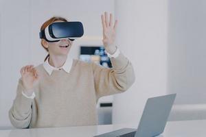 jovem garota europeia no fone de ouvido vr está gesticulando concentrado em sua visão. trabalho remoto futurista. foto