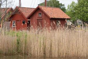 duas casas de barcos de madeira e vermelhas em fredrikstad, noruega. foto