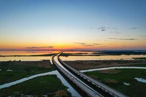 vista aérea da ponte móvel bay e jubilee parkway ao pôr do sol na costa do golfo do alabama foto