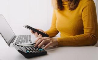 conceito de contabilidade empresarial, homem de negócios usando calculadora com computador portátil, orçamento e papel de empréstimo no escritório. foto