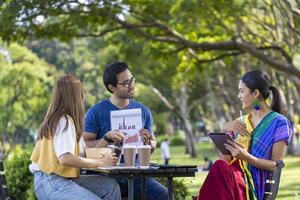 grupo de pessoas de inicialização de negócios asiáticos tendo um projeto de reunião do lado de fora no parque público durante o verão para educação universitária e brainstorming foto