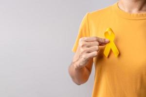 setembro amarelo, dia de prevenção do suicídio, infância, sarcoma, mês de conscientização do câncer de osso e bexiga, fita amarela para apoiar a vida e a doença das pessoas. conceito de saúde e dia mundial do câncer foto