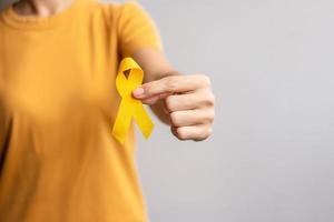 setembro amarelo, dia de prevenção do suicídio, infância, sarcoma, mês de conscientização do câncer de osso e bexiga, fita amarela para apoiar a vida e a doença das pessoas. conceito de saúde e dia mundial do câncer foto