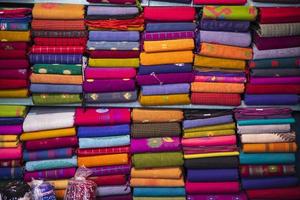 variedade artística tom cores saree empilhados na prateleira da loja de varejo para venda foto