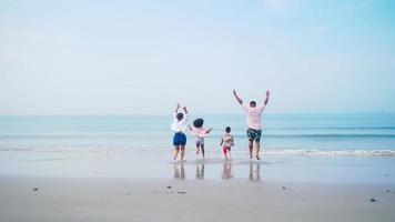 família se divertindo jogando juntos na praia. foto