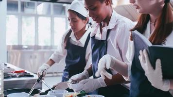 grupo de alunas se divertindo aprendendo a cozinhar. estudantes do sexo feminino em uma aula de culinária. foto